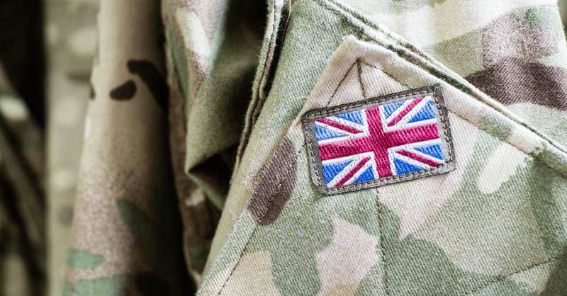 A union jack patch sewn onto camouflage-patterned fabric, representing the UK defence industry